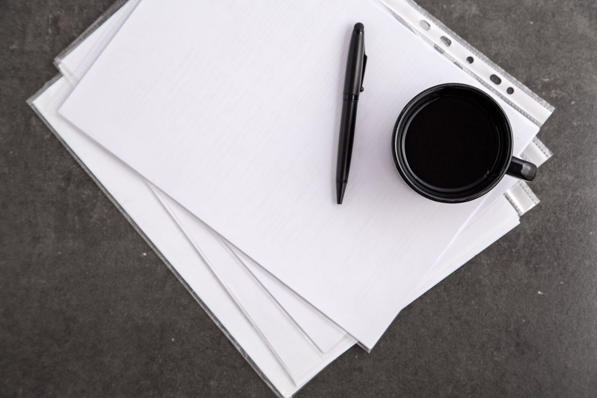 Paper sheet with copy space and black pen with cup coffee