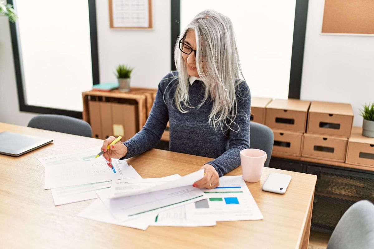 Middle age grey-haired woman business worker smiling confident working at office