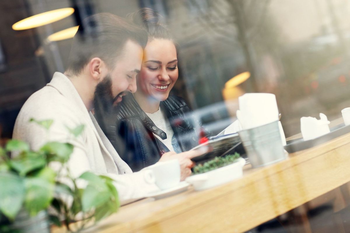 Happy couple reading guide in restaurant