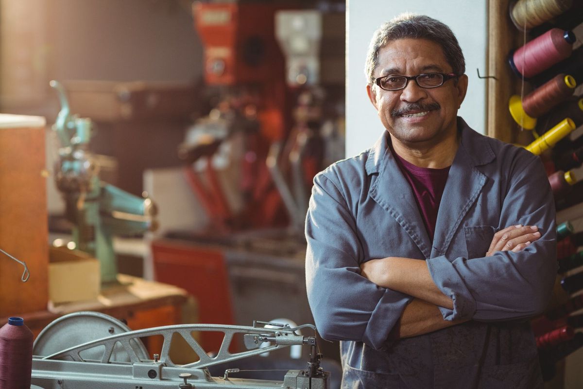 Portrait of shoemaker standing with arms crossed