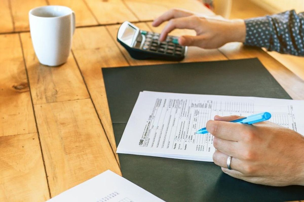 Male adviser filling in tax documents in office