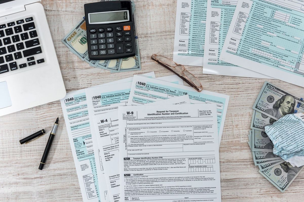 1040 tax form on desk with pen calculator and us dollar. business concept