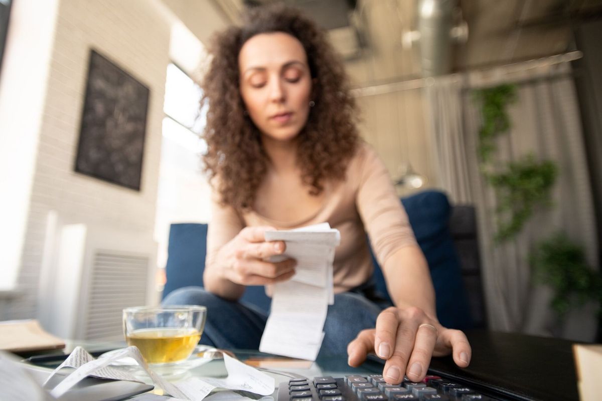 Hand of young female owner of modern restaurant or cafe pressing buttons of calculator