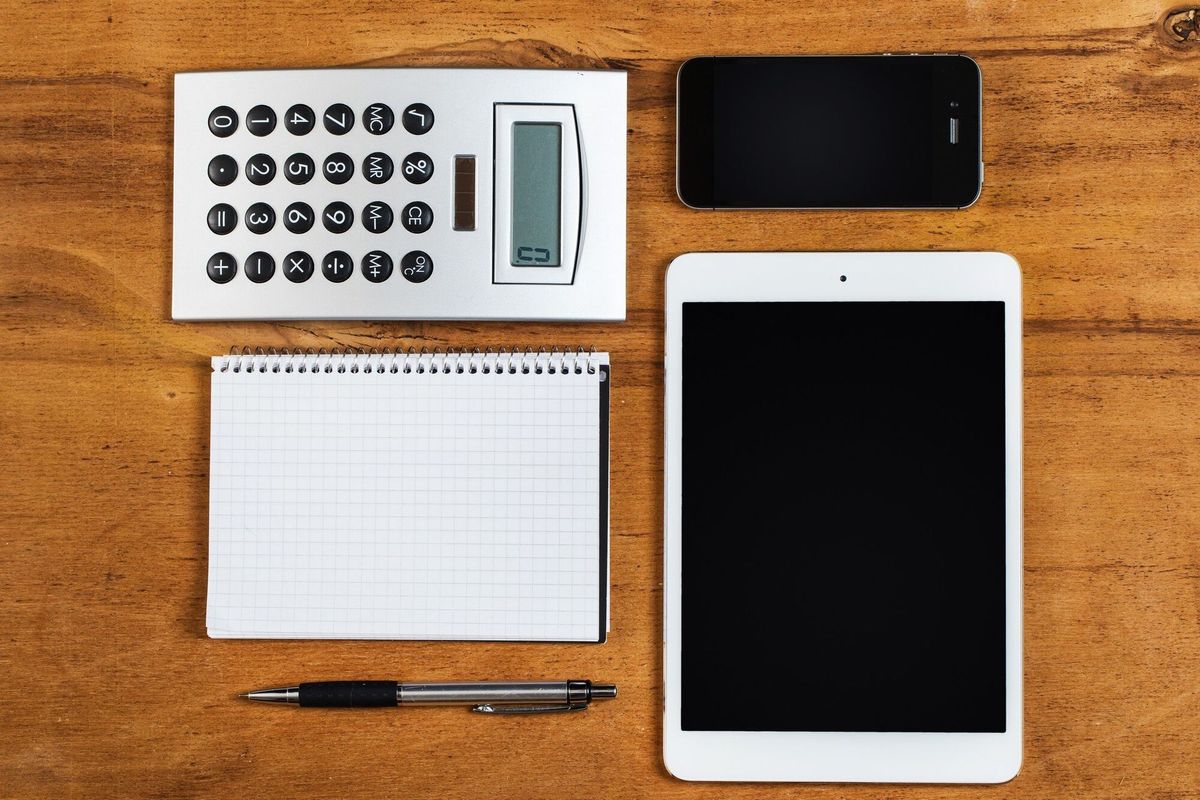 Workplace. Phone, tablet and notepad on the table