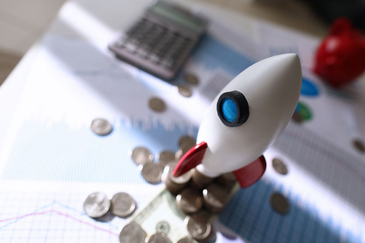On color chart is toy space rocket and coins lie on table
