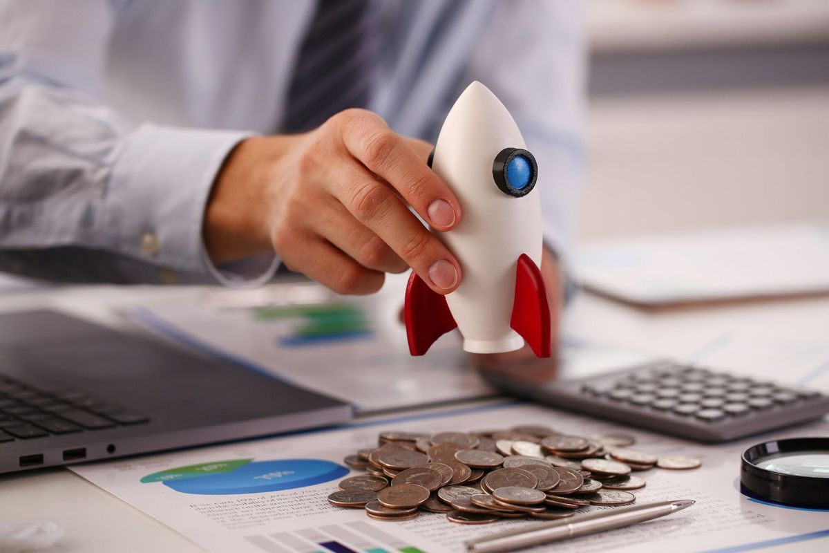 Businessman in suit hold white rockrt in hand