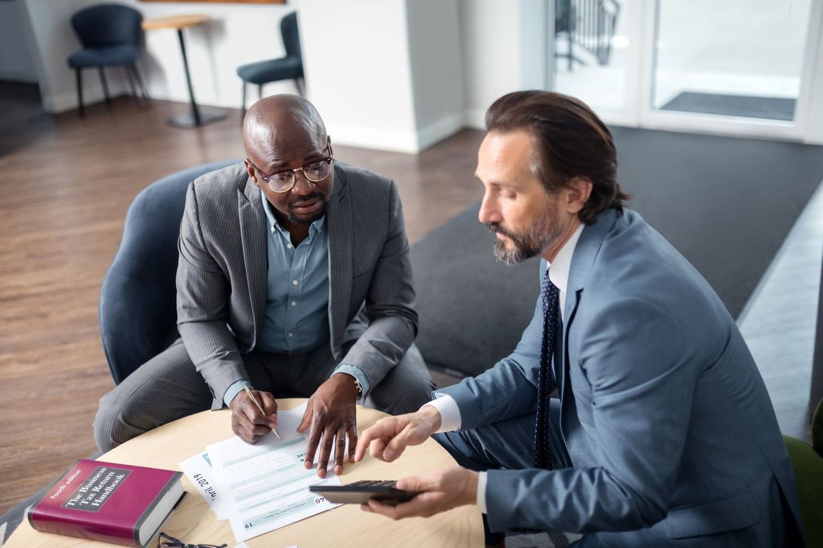 Consulting businessman. Grey-haired professional economist consulting businessman in the office