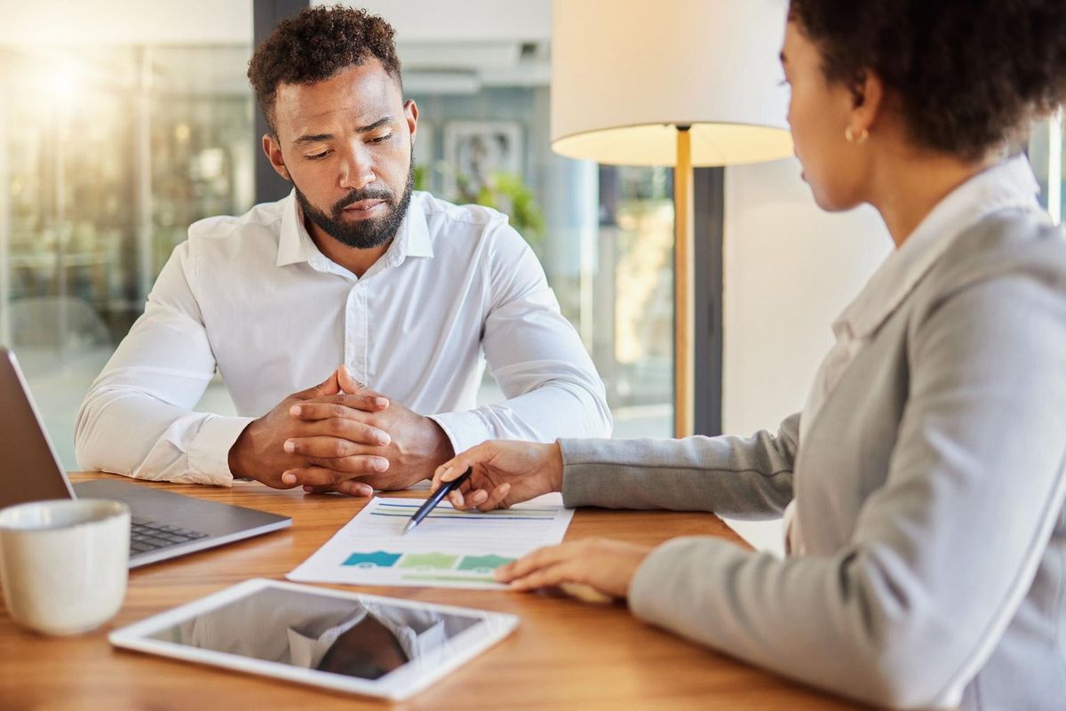 Accountant consulting an entrepreneur about company financial performance in an office using statistics Finance advisor in a meeting having a business growth strategy discussion with businessman